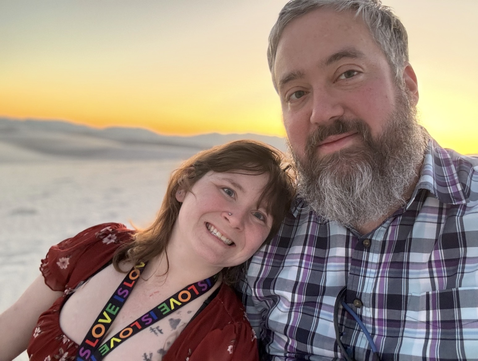 Riva and Jonathan smiling together at sunset