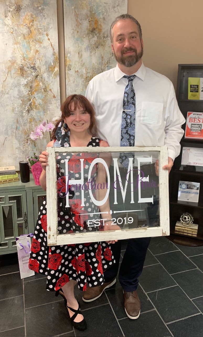 Riva and Jonathan holding a home sign